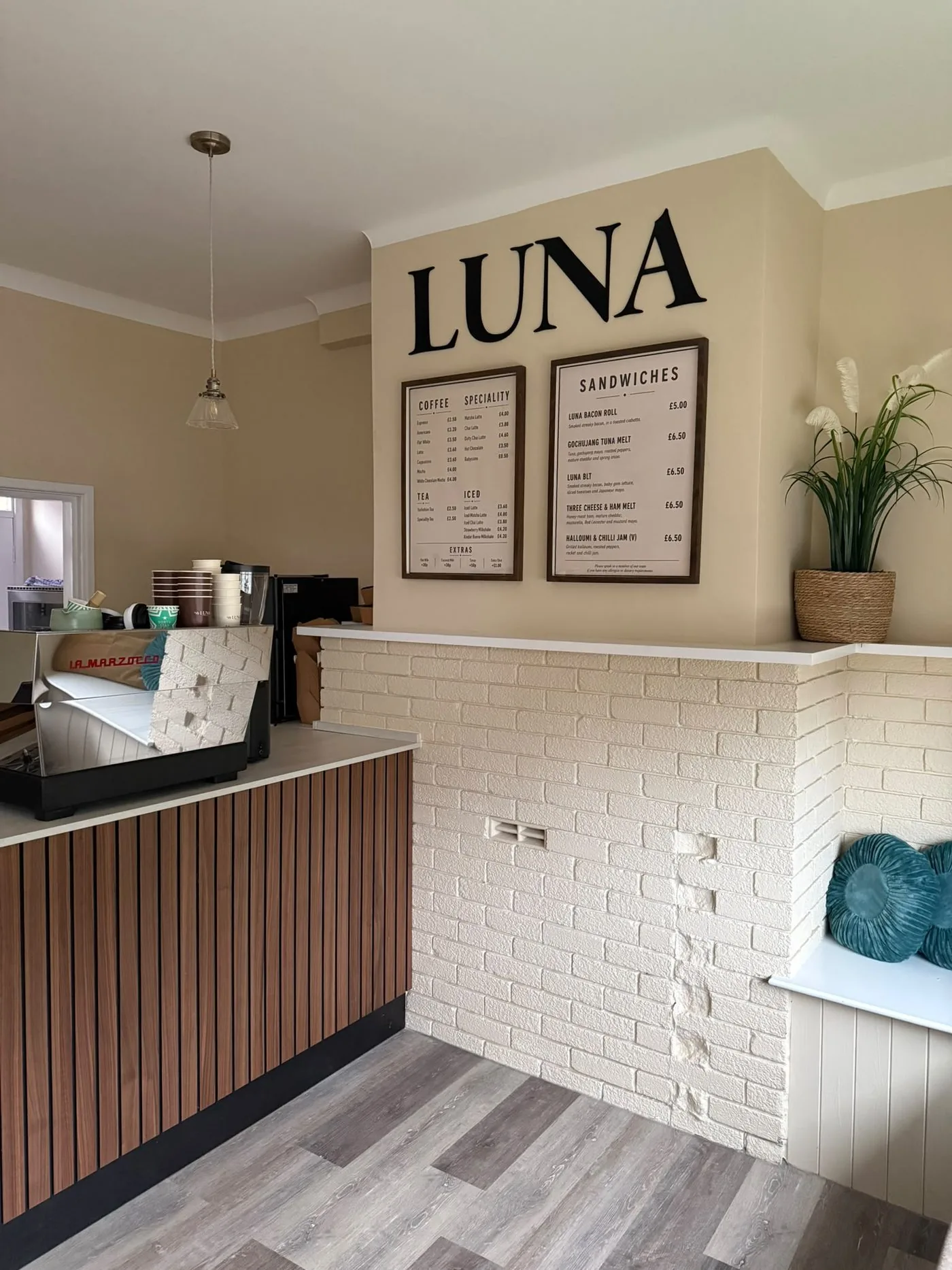 Inside Luna Coffee House with counter, menu boards and seating