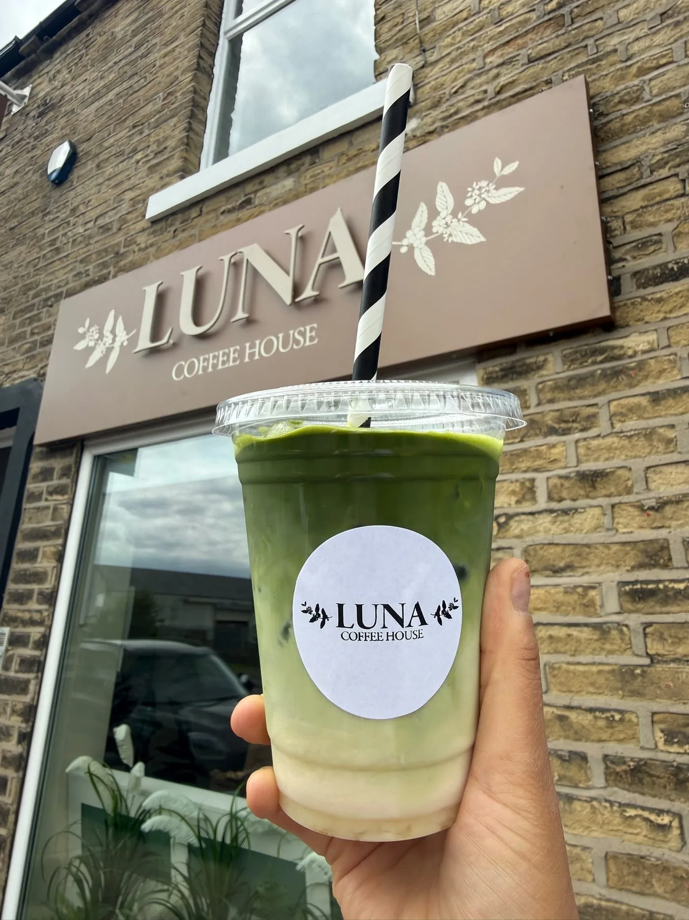 Iced matcha with Luna Coffee House branding outside the shop